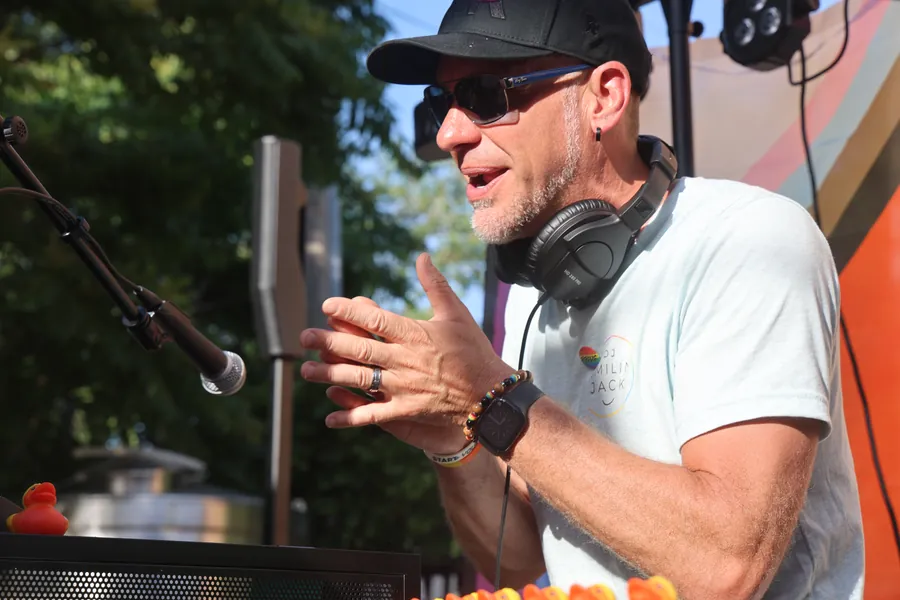 DJ Smilin' Jack mid-set behind the booth, headphones around his neck